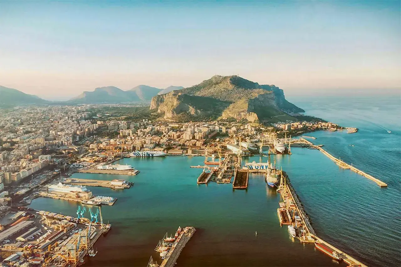 Palermo mit Kindern: Ein Blick auf den Hafen mit Schiffen und dem Monte Pellegrino im Hintergrund. Perfekt für einen Familienausflug!