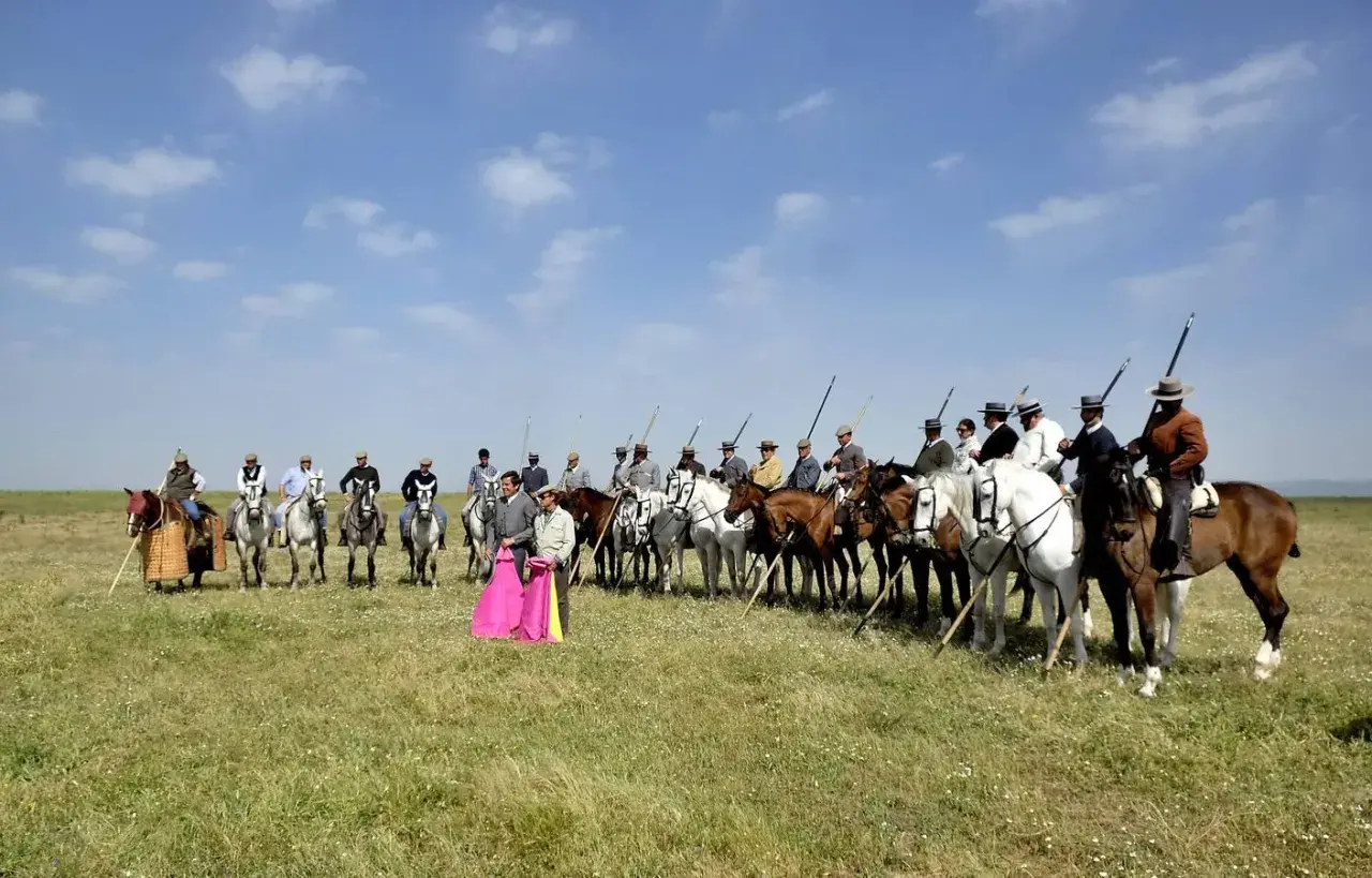Hombres a caballo, algunos con trajes de luces, listos para la lidia. Eduardo Miura, un nombre ligado a la tauromaquia, podría estar entre ellos.