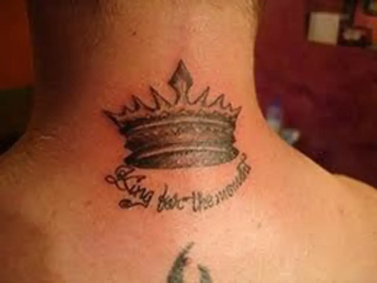 Męski tatuaż na szyi: korona z napisem "King for the moment".