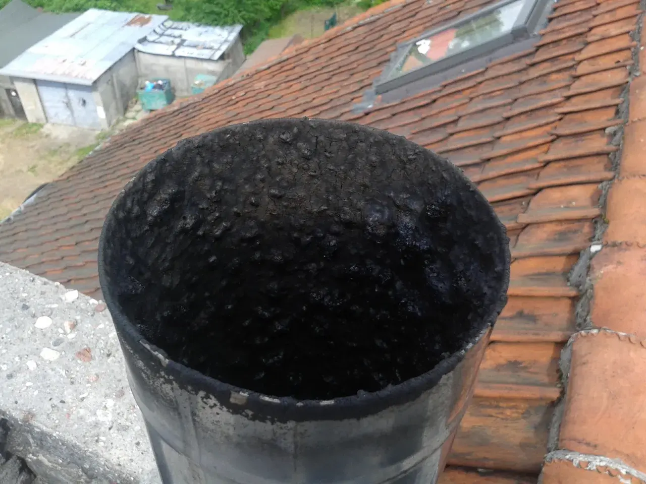 Zatkana sadzą rura kominowa. Zastanawiasz się, ile wytrzymuje wkład kominowy? Ten widok sugeruje, że czyszczenie jest konieczne.