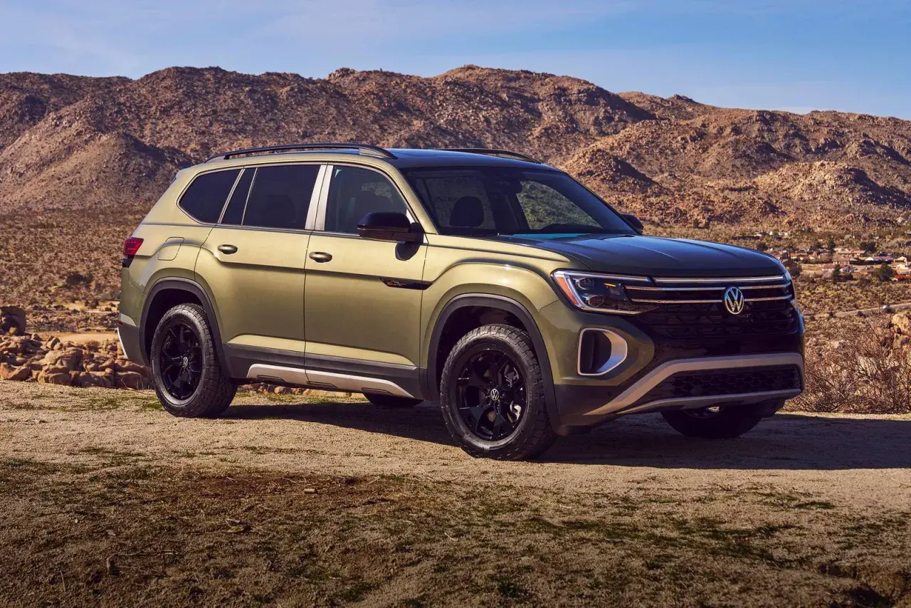Zielony VW Atlas z czarnymi felgami na tle pustynnego krajobrazu.
