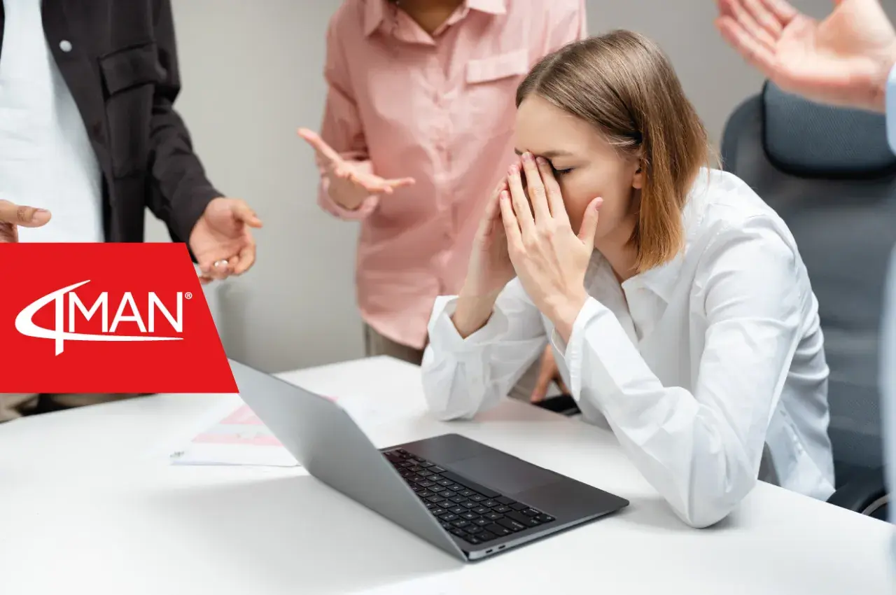 Giovane donna stressata in ufficio, circondata da colleghi agitati. Un esempio di crisi management.