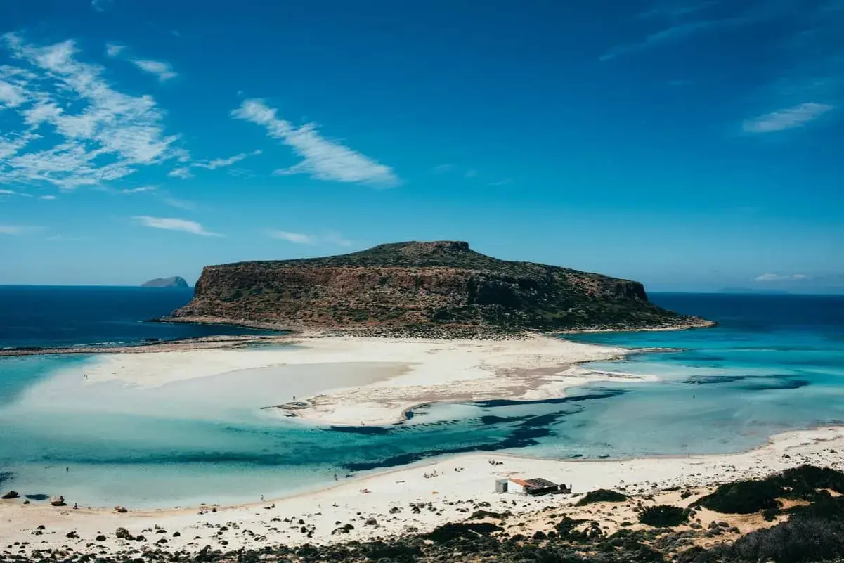 Traumhafte Lagune mit türkisfarbenem Wasser und einer imposanten Berginsel. Welche griechische Insel könnte das sein? Balos auf Kreta.