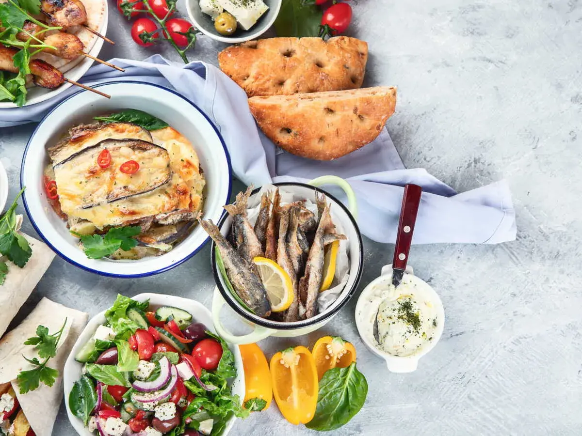 Un festin méditerranéen : brochettes, moussaka, poisson frit, salade grecque, pain et sauce. Un menu de la semaine alléchant !