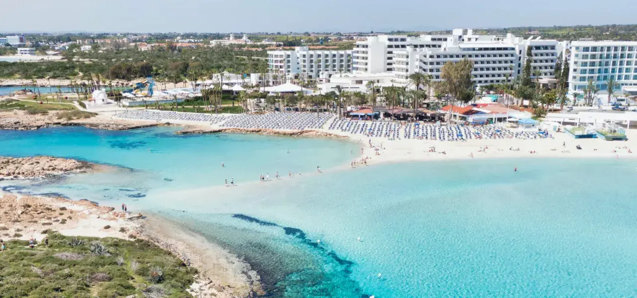 Piękna plaża z turkusową wodą i białymi hotelami. Czy Cypr to państwo, które oferuje takie widoki? Tak, to raj dla turystów!
