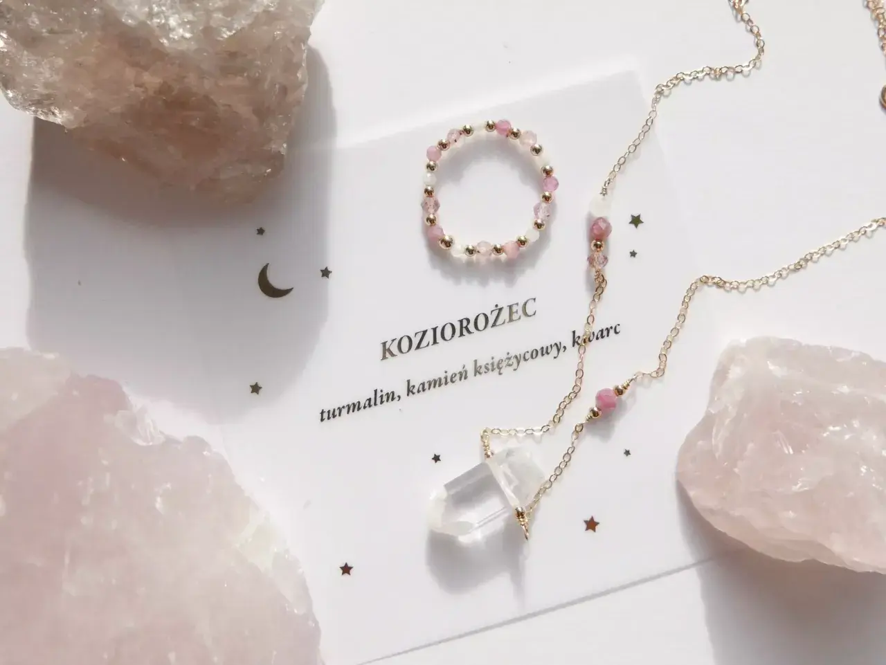 Delikatna biżuteria z różowych kamieni i kryształu, ozdobiona gwiazdkami i księżycem, nawiązuje do znaku zodiaku Koziorożec.