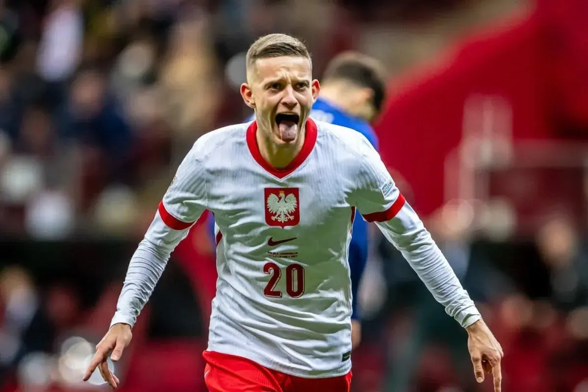 Sebastian Szymański w koszulce reprezentacji Polski, z numerem 20. Jego radość sugeruje udany występ, może to zapowiedź jego przyszłego sebastian szymański transfer.