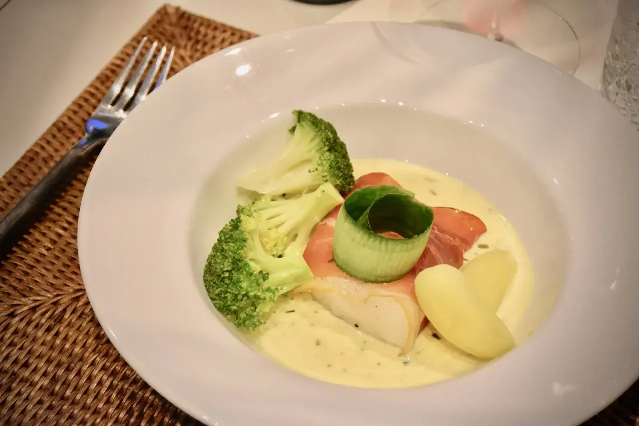 En vacker tallrik med fisk, broccoli och potatis i en krämig sås. Perfekt för en middag med vin till Sandefjordsås.