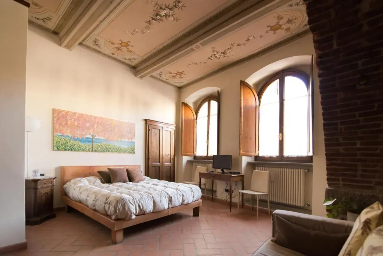 Camera da letto con soffitto affrescato, letto comodo e vista su Arezzo dove dormire.
