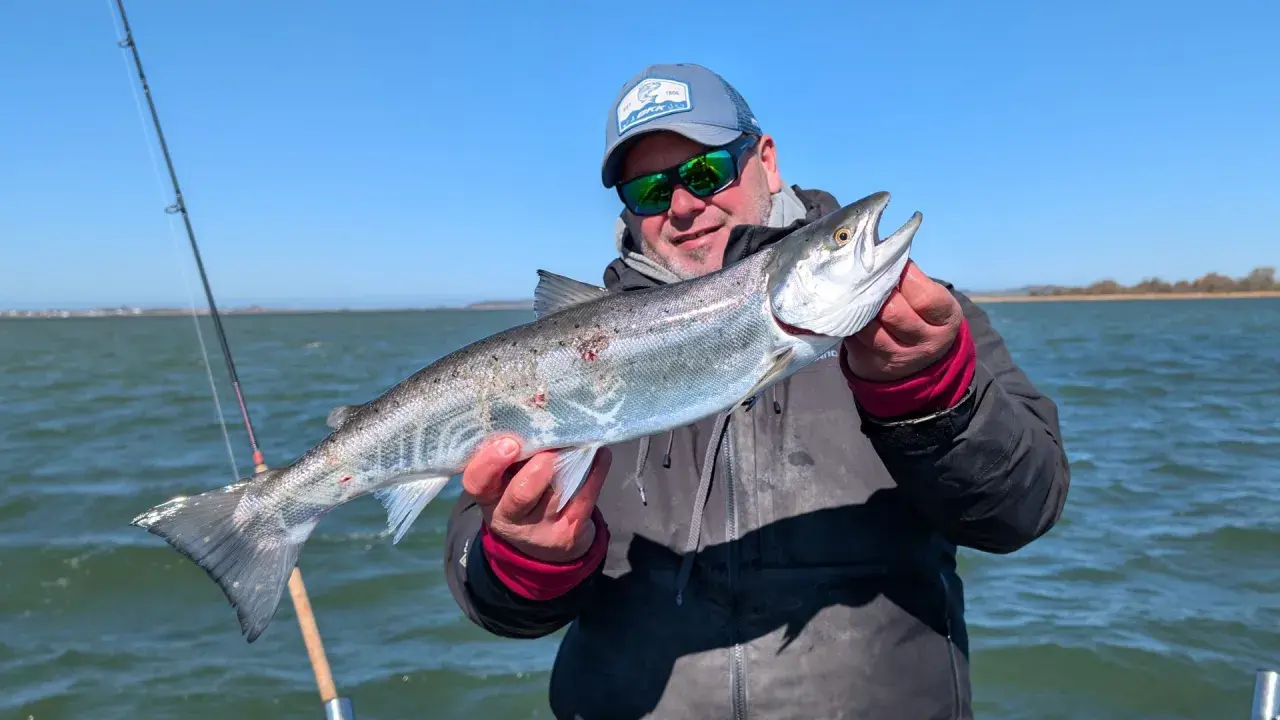 Glücklicher Angler hält stolz einen großen Fisch, den er beim Limburg Angeln gefangen hat.