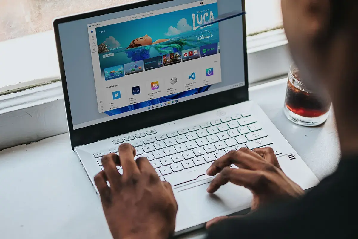 Osoba korzysta z laptopa z systemem Windows 11, przeglądając sklep z aplikacjami. Czy Windows 11 jest darmowy? Sprawdźmy!