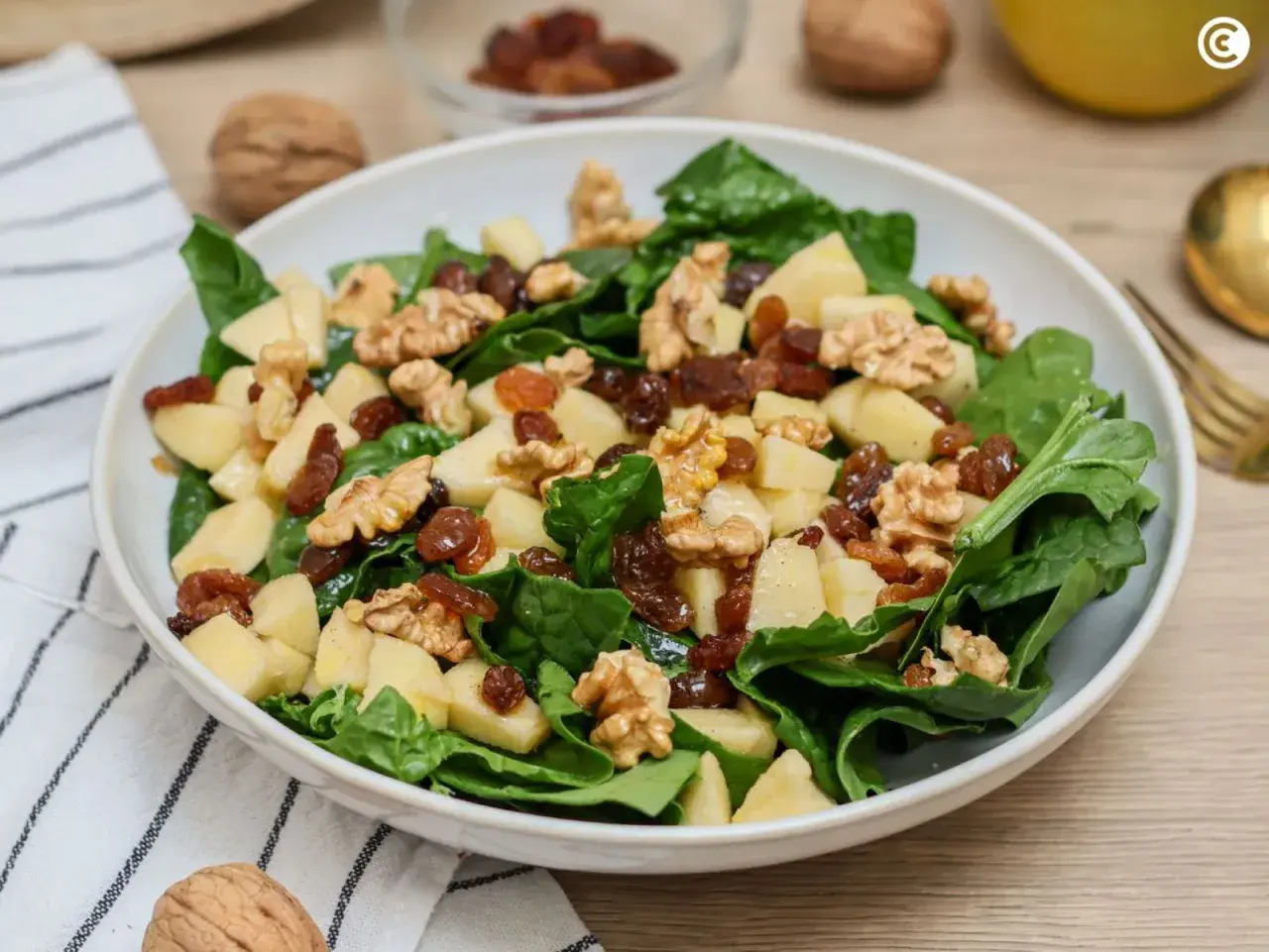 Ensalada fresca con espinacas, manzana, nueces y pasas. Una de las muchas deliciosas recetas con espinacas.
