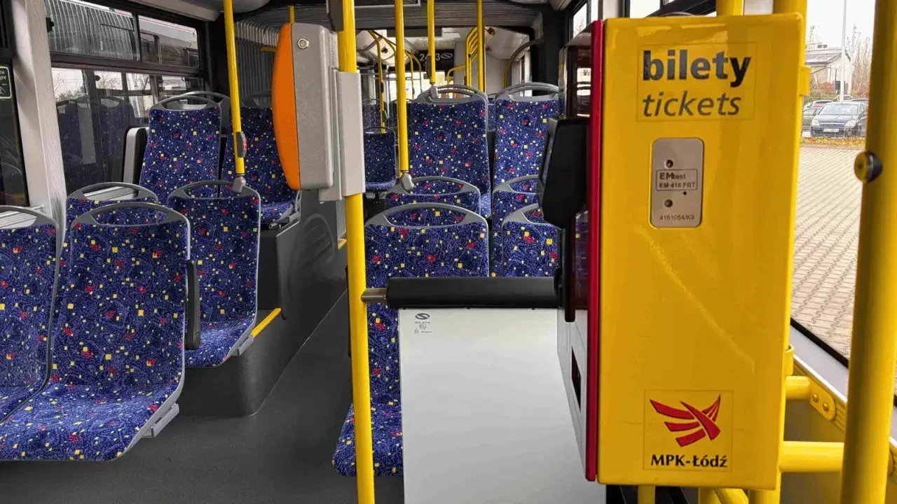 Wnętrze autobusu MPK-Łódź. Żółty automat biletowy z napisem "bilety tickets" obok siedzeń. Sprawdź bus łódź - uniejów cennik.