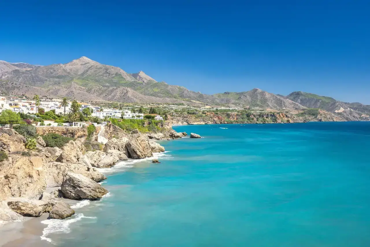 Costa de Nerja, Málaga, con sus casas blancas en acantilados y el mar turquesa.