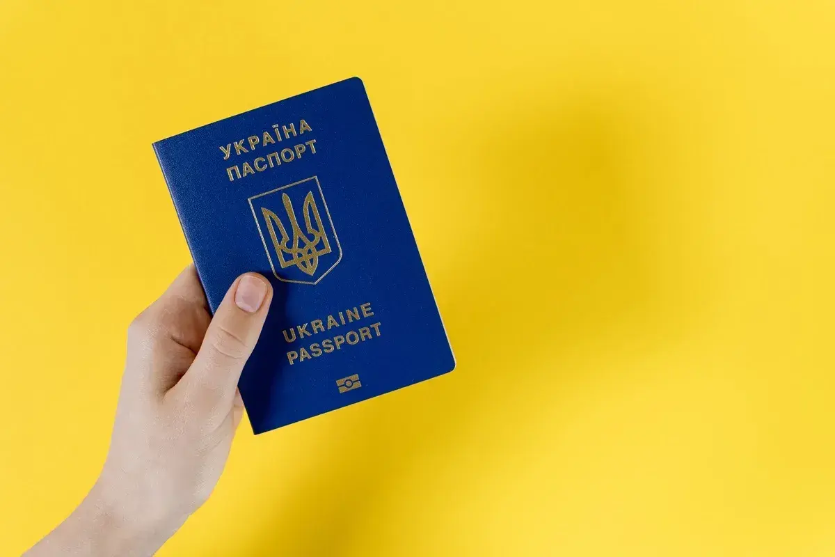 Dłoń trzyma paszport Ukrainy. Specustawa Ukraina ułatwia obywatelom Ukrainy dostęp do dokumentów.