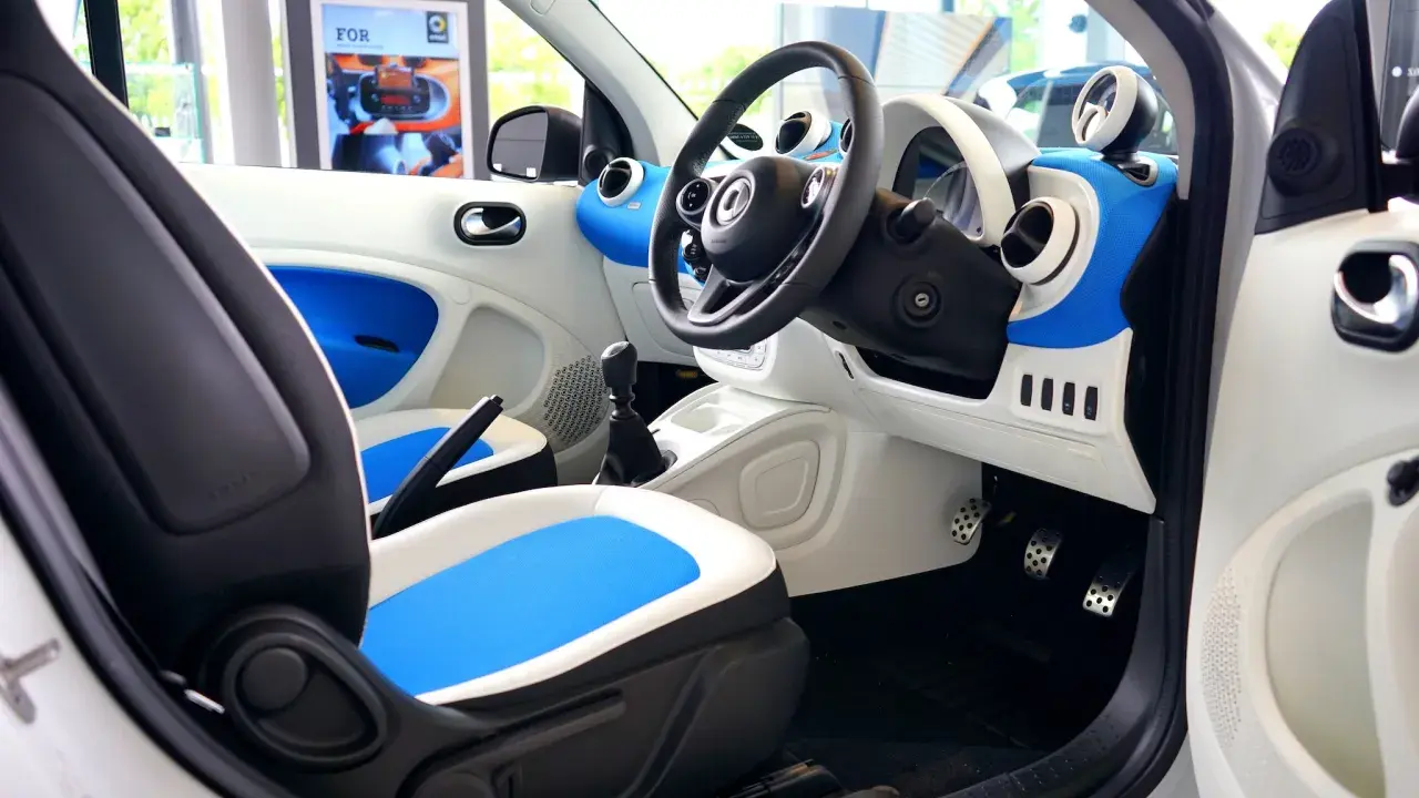 Wnętrze samochodu Smart. Widoczne pedały: po lewej hamulec, po prawej gaz.