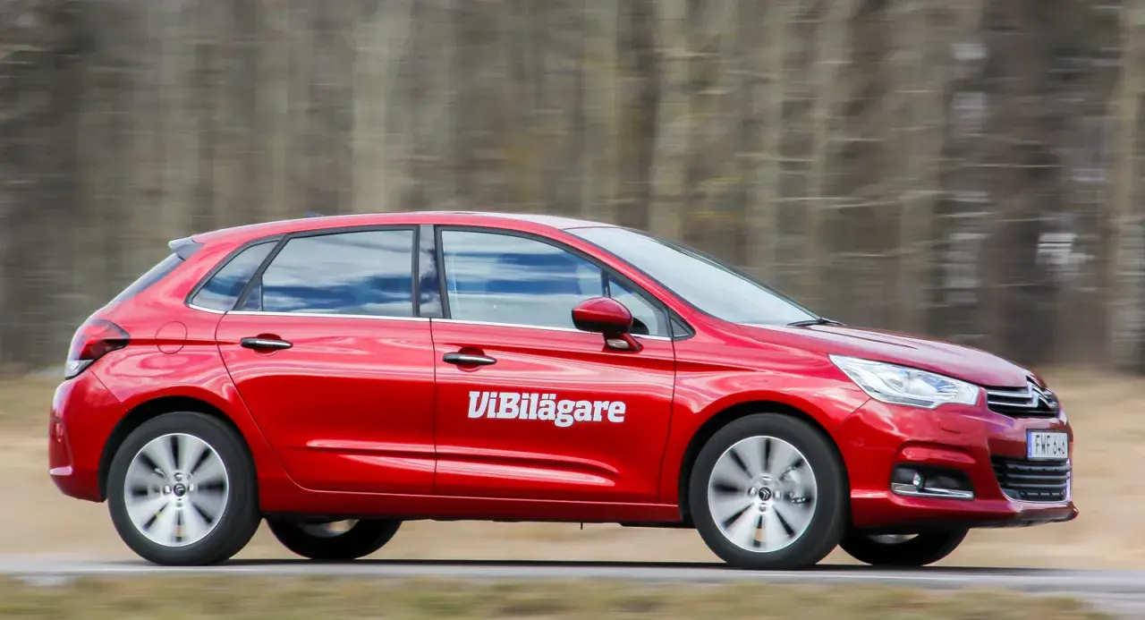Röd Citroen C4 i fart, med texten "Vi Bilägare" på sidan. Bilen är på en väg med träd i bakgrunden.