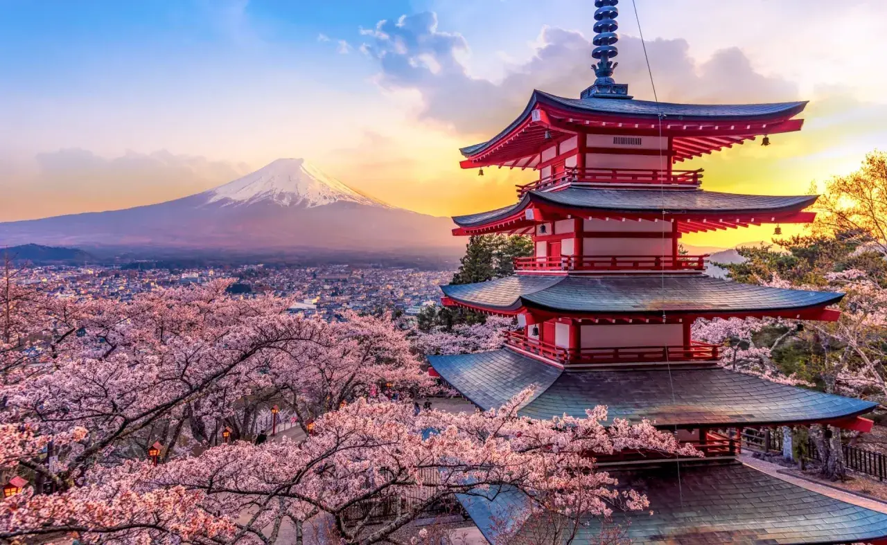 Japonia wycieczka Itaka: Czerwona pagoda i kwitnące wiśnie na tle góry Fudżi o zachodzie słońca.