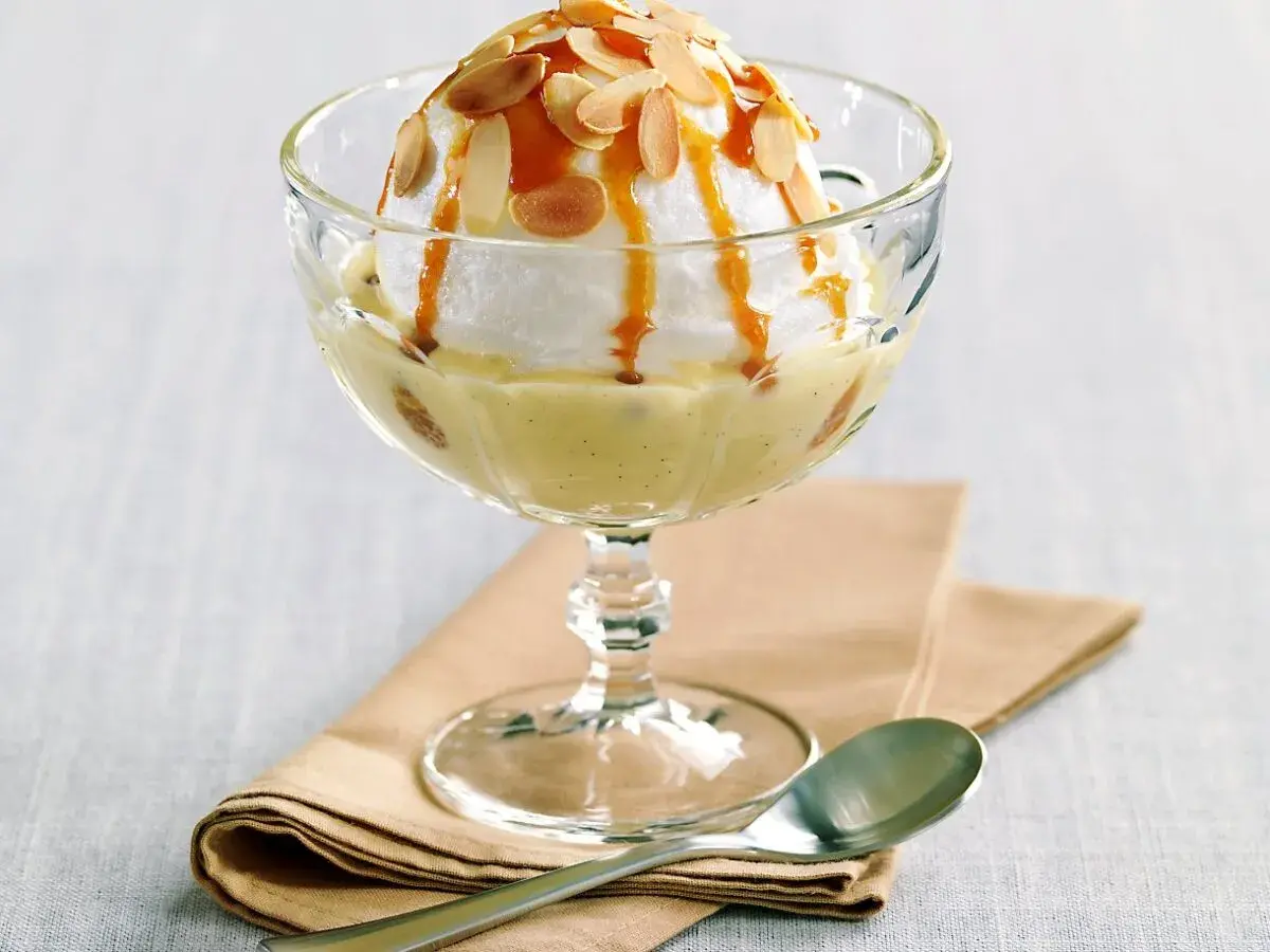 Île flottante, une recette de grand-mère réconfortante. Nuage de meringue, crème anglaise vanillée, caramel et amandes effilées.