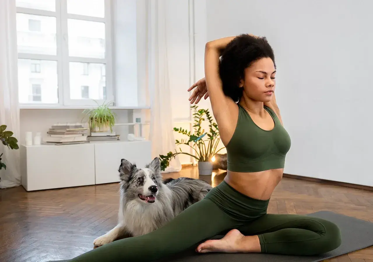 Frau dehnt sich mit ihrem Hund, um gelenkiger zu werden.
