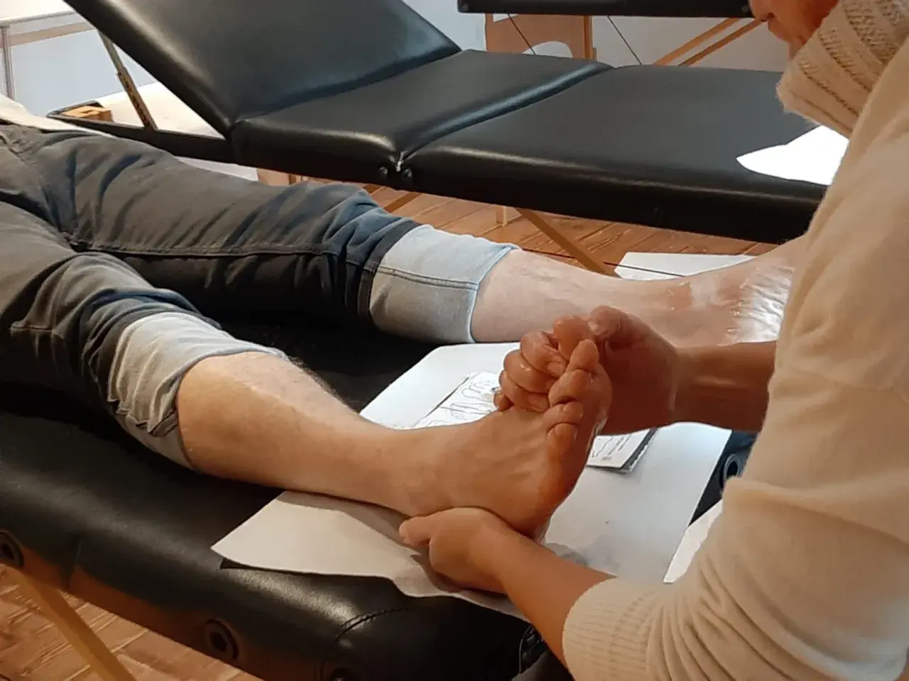 A person's foot is being massaged by another person's hands.