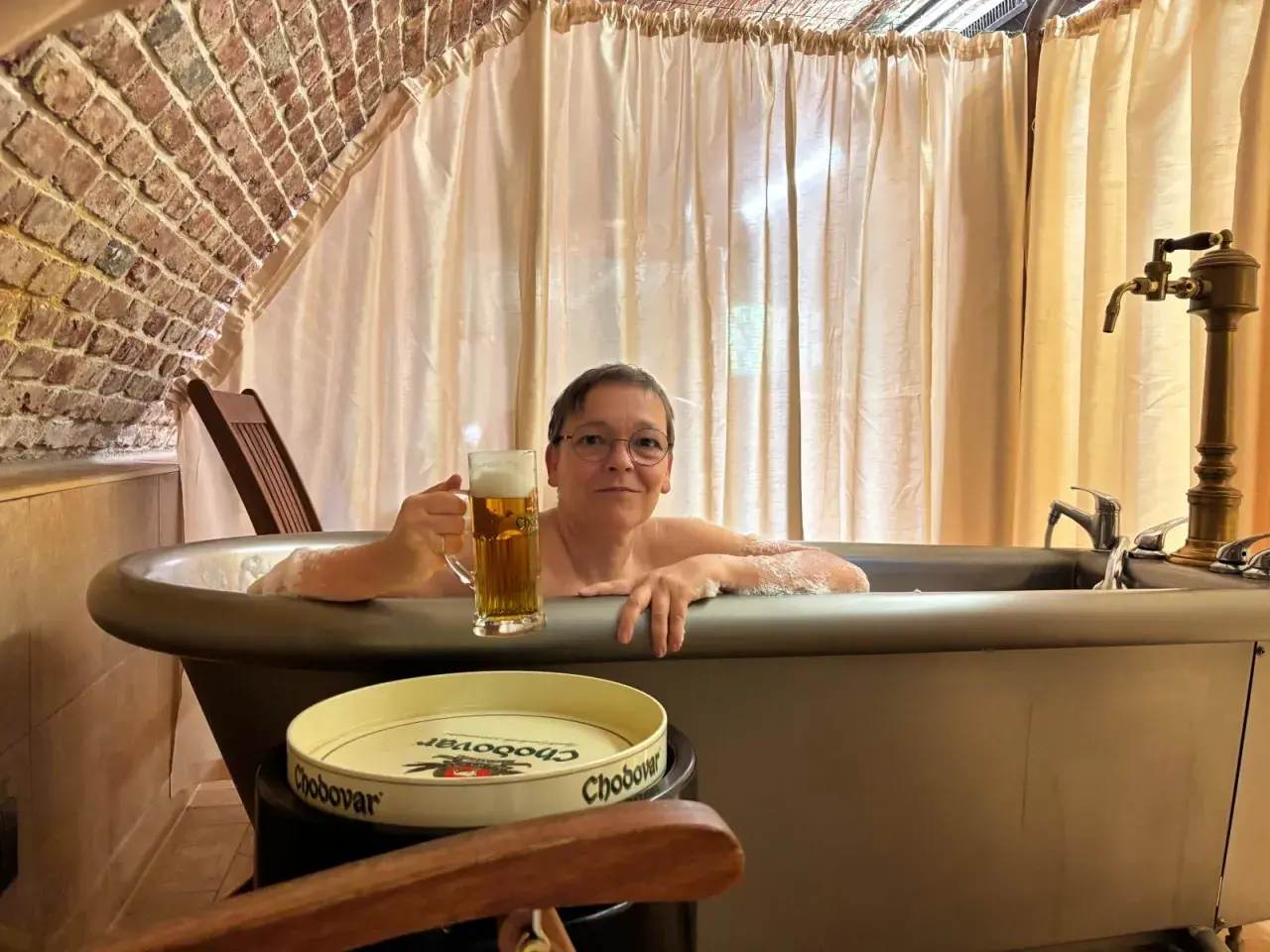 Entspannte Frau mit Bier im Bad des Chodovar Hotels.
