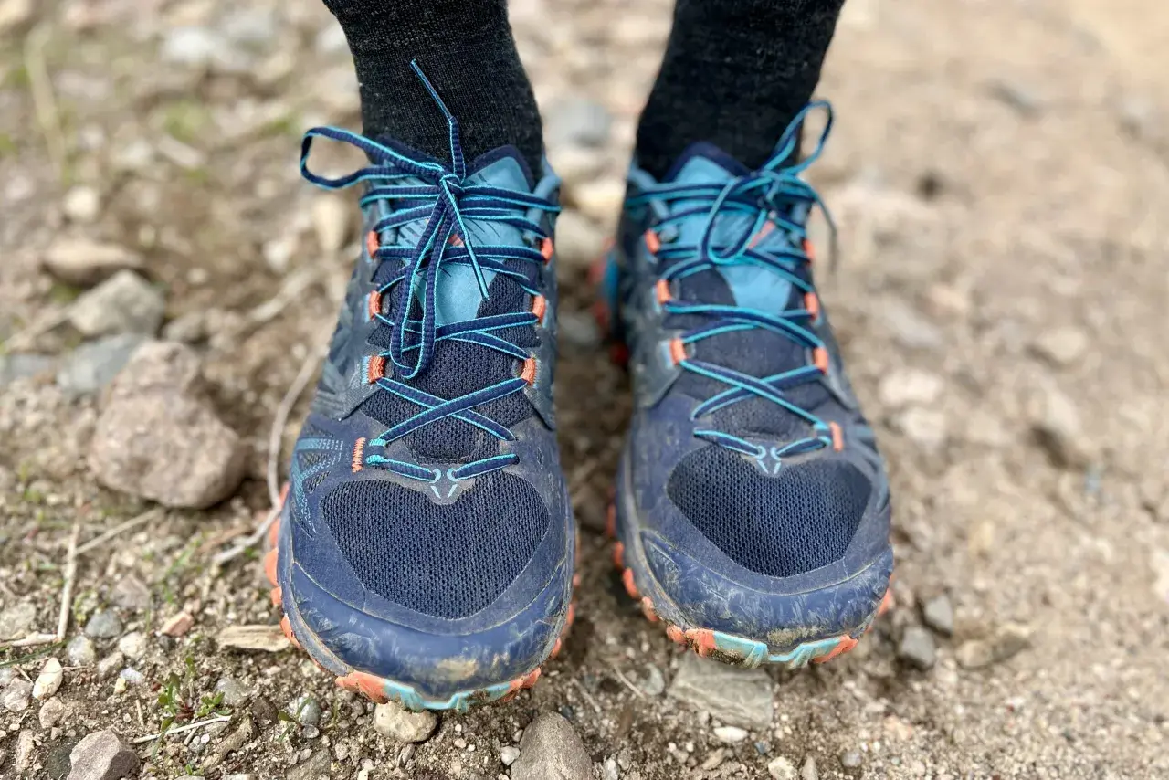 Close-up of a pair of La Sportiva Bushido III trail running shoes, laced up and ready for adventure on a rocky path.