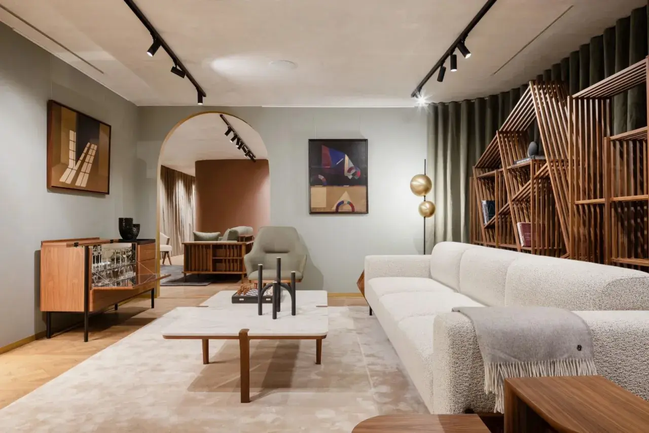 Un salon à la décoration épurée, avec un canapé blanc texturé, une étagère en bois géométrique et des œuvres d'art modernes.