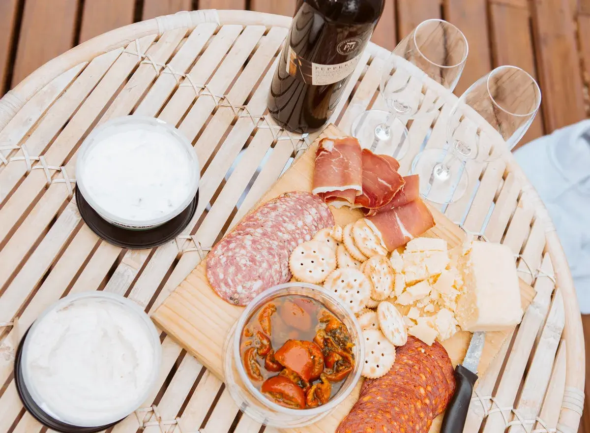 Un plateau de charcuterie, fromages et trempettes, prêt à être dégusté avec un bon vin. Quel vin avec charcuterie ? C'est la question parfaite pour ce moment convivial.