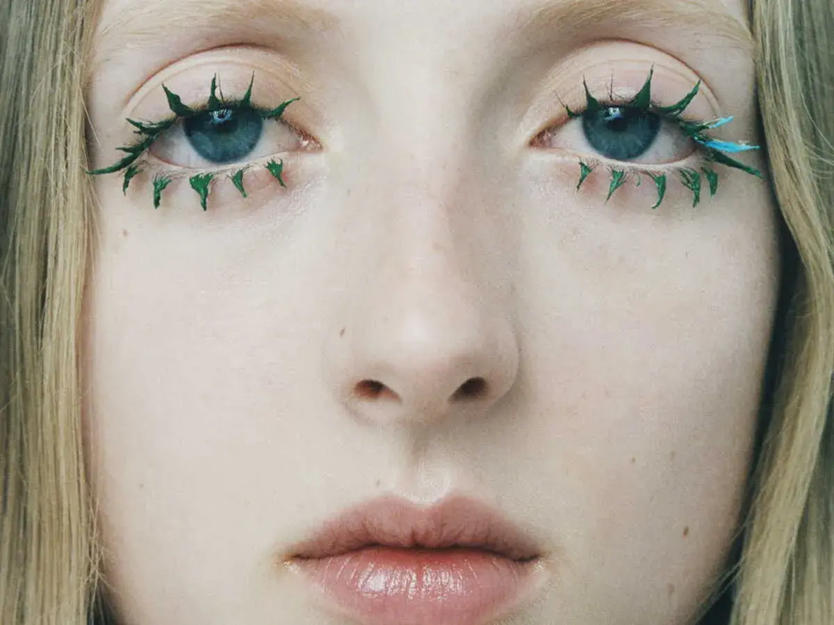 Yeux bleus aux cils verts et bleus, comme un mascara yeux qui pleurent artistiquement appliqué.