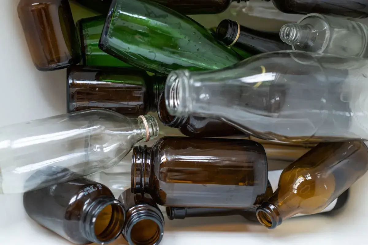 Stos szkła do recyklingu: brązowe i zielone butelki, ciekawe ciekawostki o recyklingu.