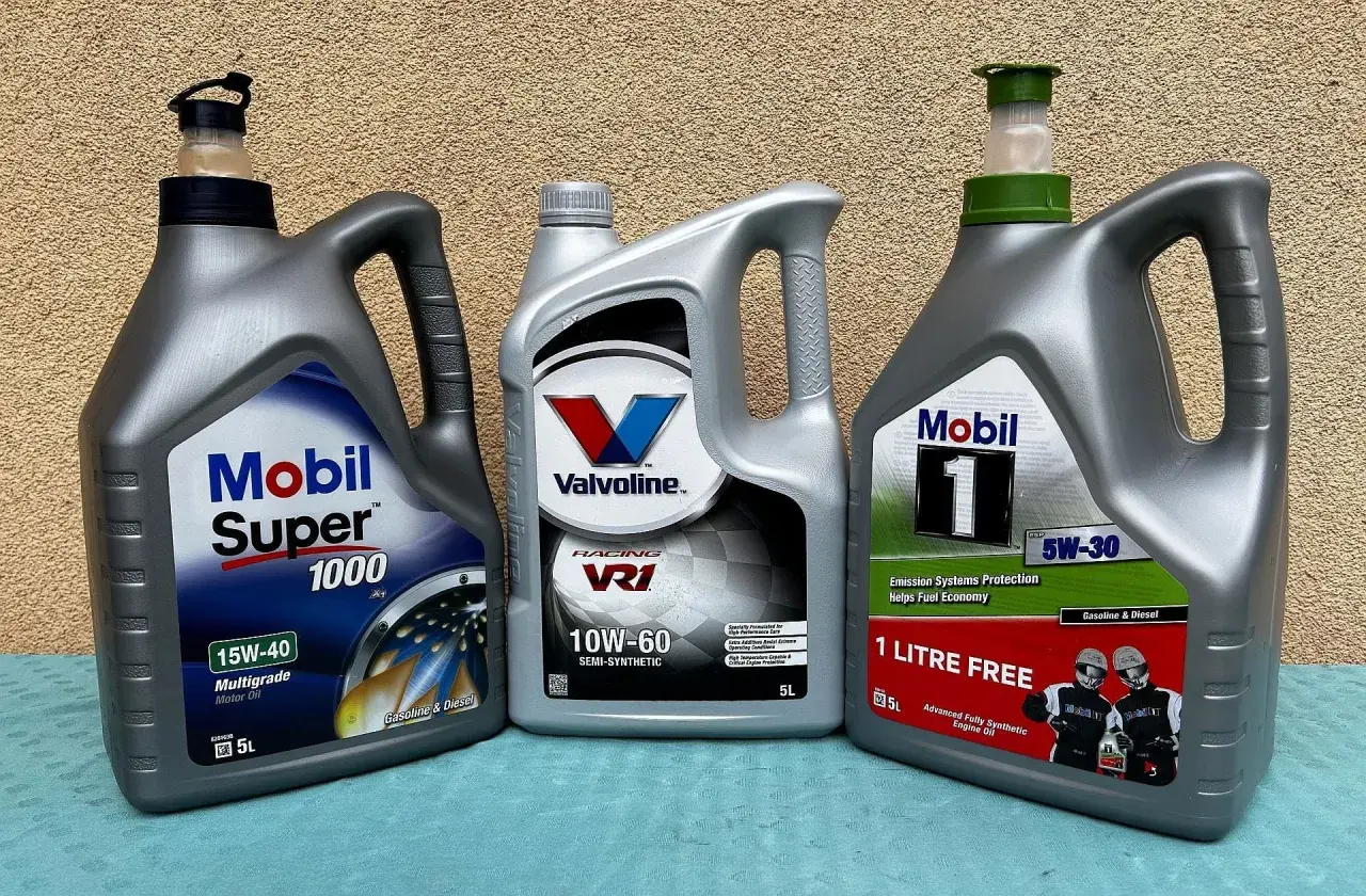 Trzy bańki z olejem silnikowym: Mobil Super 1000, Valvoline VR1 (półsyntetyczny) i Mobil 1 (syntetyczny).