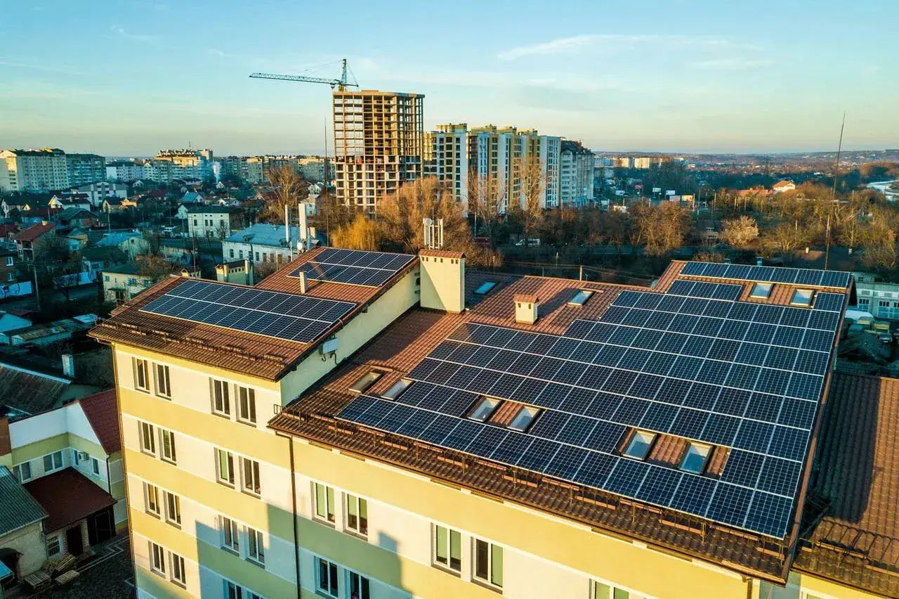 Panele fotowoltaiczne na dachu bloku mieszkalnego. Fotowoltaika we wspólnocie mieszkaniowej to przyszłość zielonej energii.