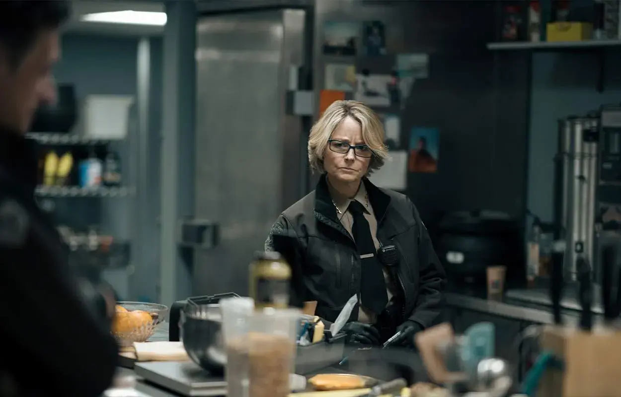 Jodie Foster som polis i True Detective säsong 5, med en allvarlig blick i ett kök.