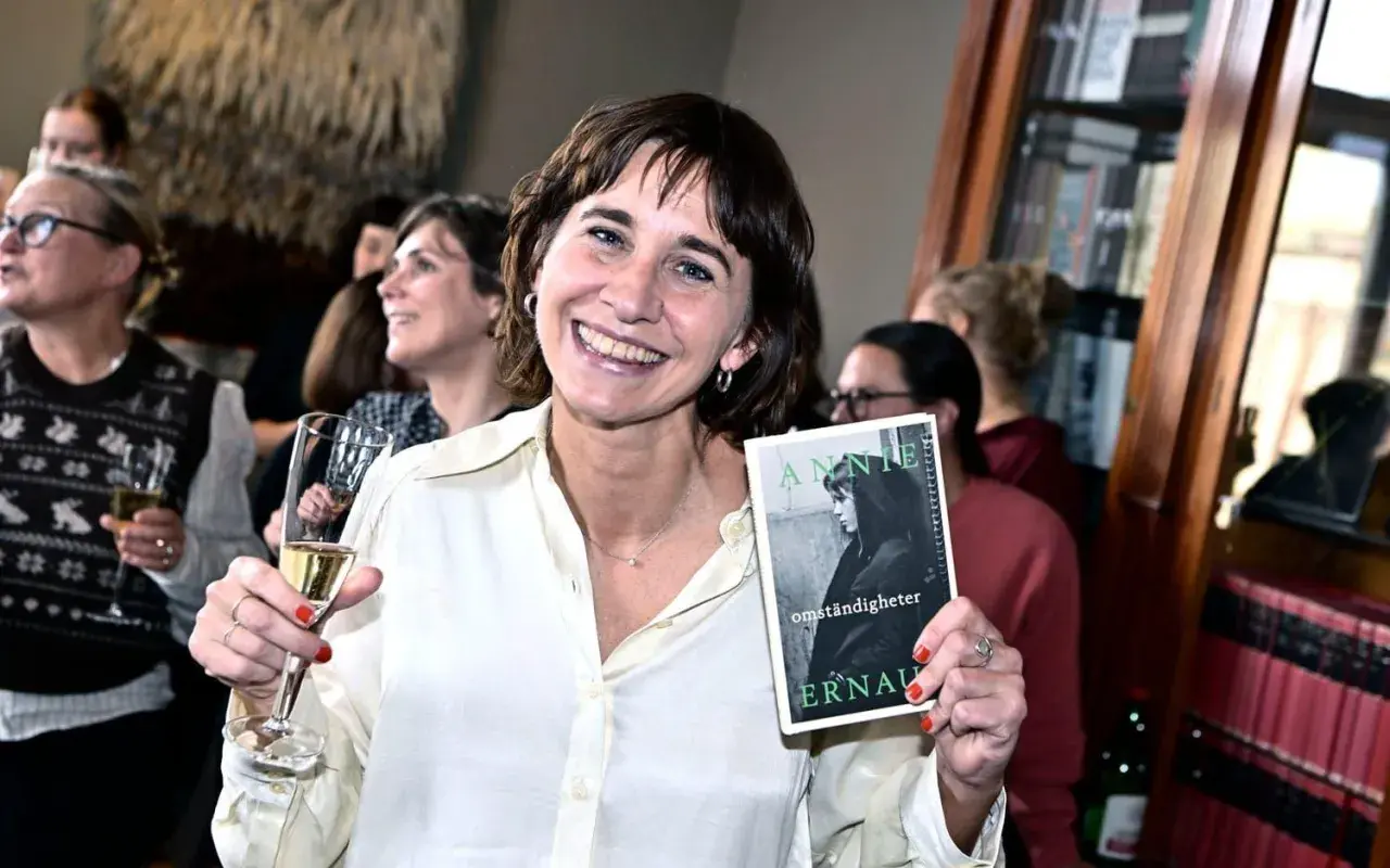 Lisa Lindberg håller upp boken "Annie Ernaux: Omständigheter" vid ett Norstedts-event.