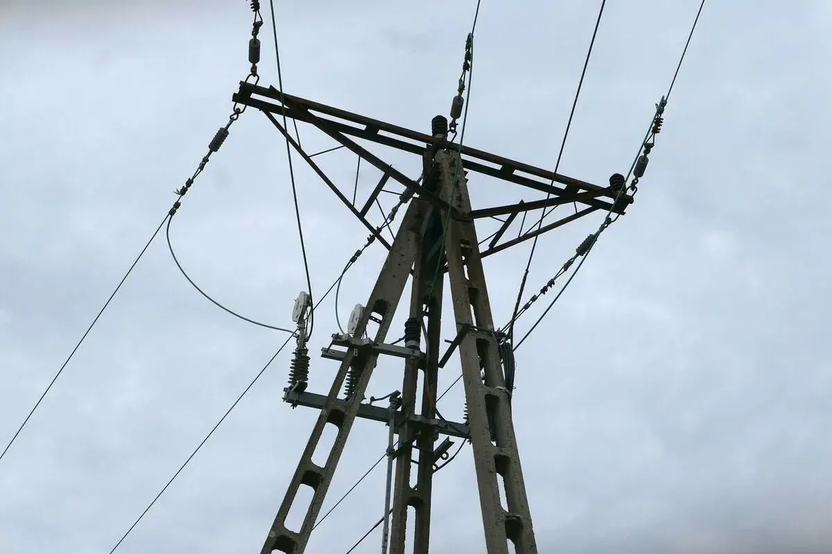 Betonowy słup energetyczny z przewodami, może być związany z awarie prądu Tauron.