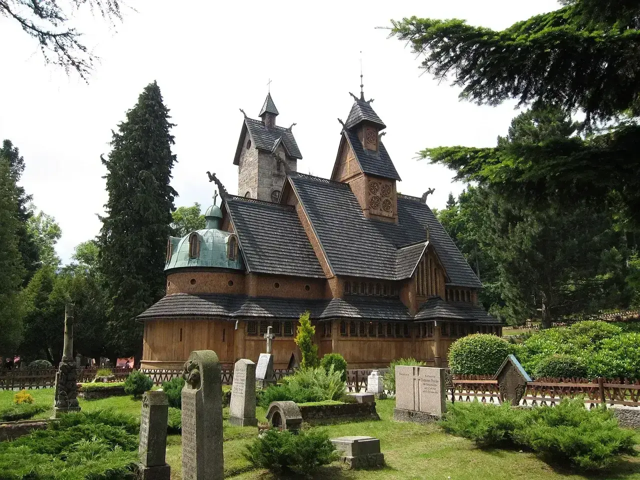 Drewniana świątynia Wang w Karpaczu, otoczona cmentarzem i zielenią. Ciekawostki o jej budowie i historii przyciągają turystów.