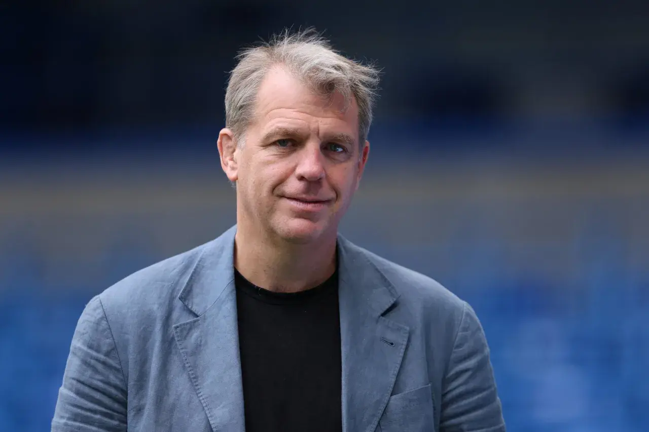 Todd Boehly, właściciel Chelsea, w niebieskiej marynarce na tle stadionu.