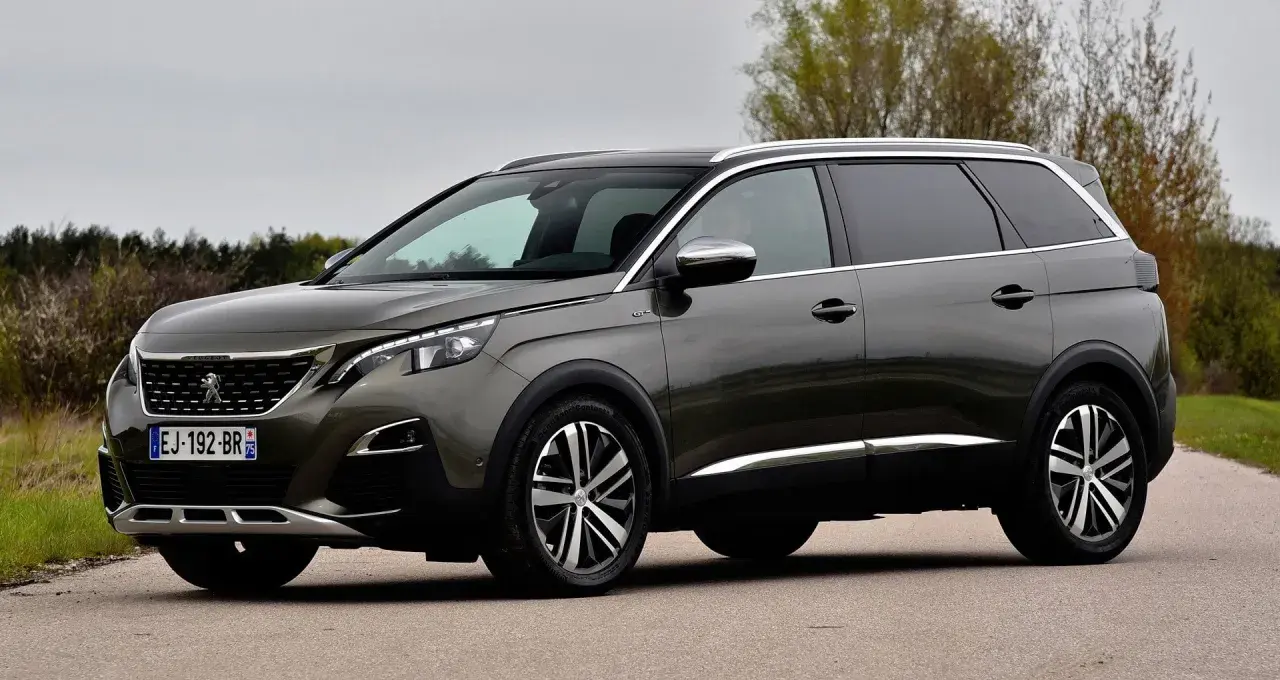 Szary Peugeot 5008 na drodze, widoczne felgi i opony. Rozmiar opon jest kluczowy dla komfortu jazdy tym SUV-em.