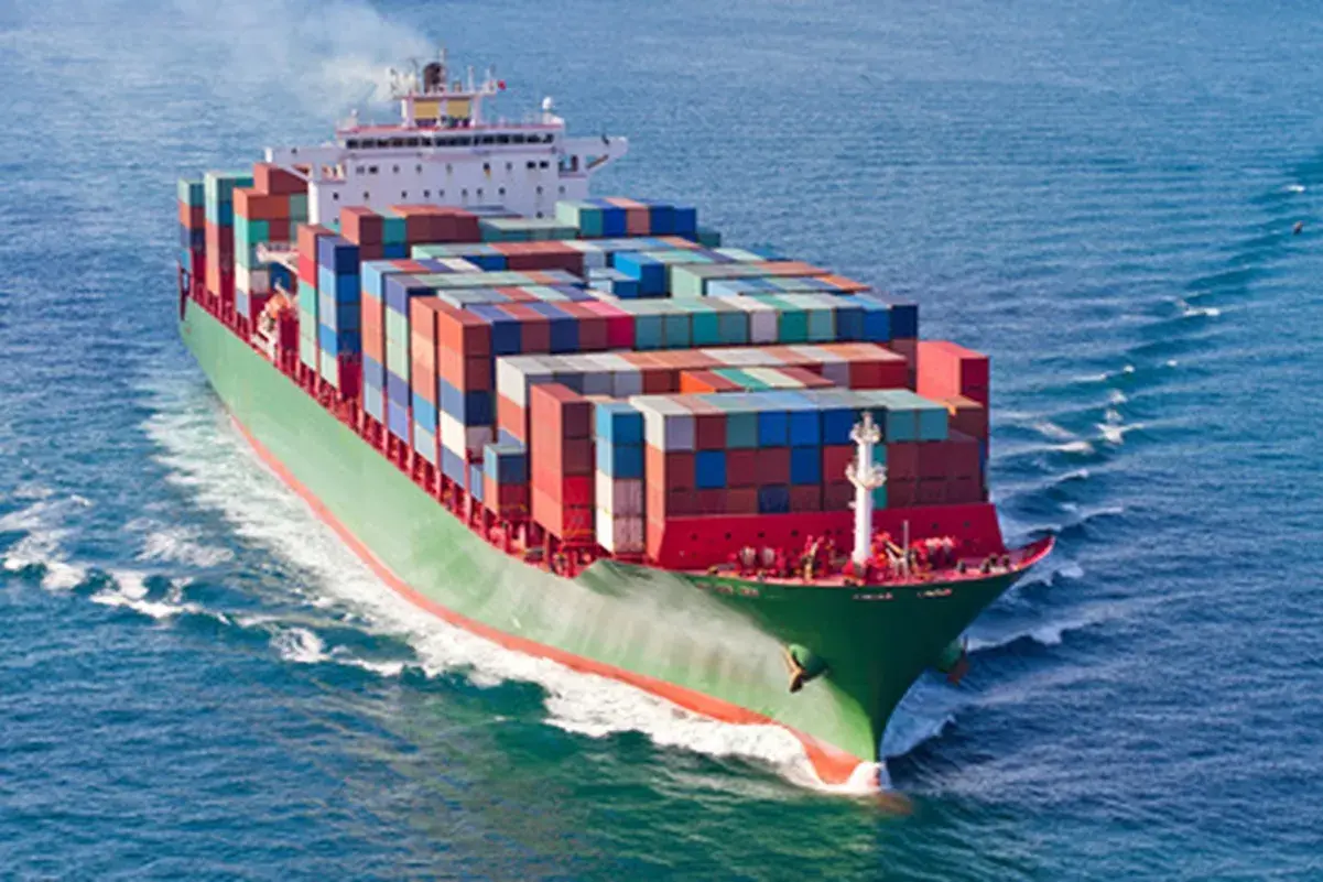Ein riesiges Containerschiff fährt auf dem Meer. Die Fracht, die die Bedeutung von Frankatur symbolisiert, ist sicher verstaut.