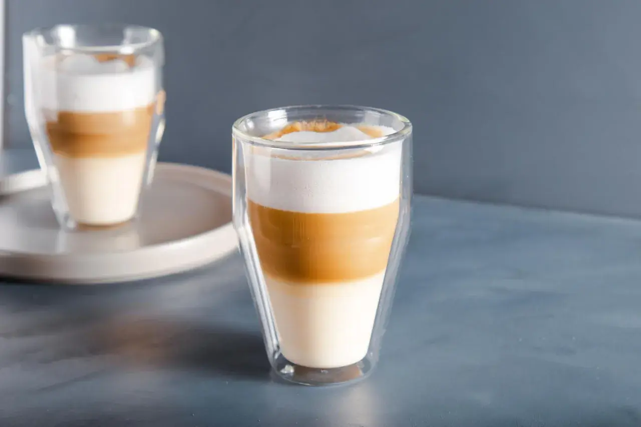 Jak zrobić latte macchiato? Warstwy mleka i kawy w szklance.
