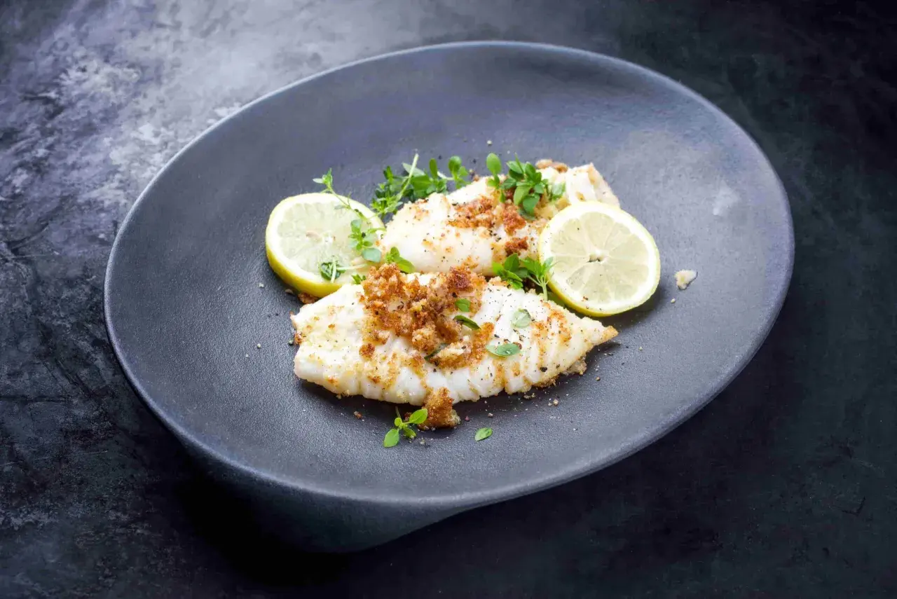Calamares a la plancha con limón, cubiertos de pan rallado crujiente y hierbas frescas. Un plato ligero y sabroso.