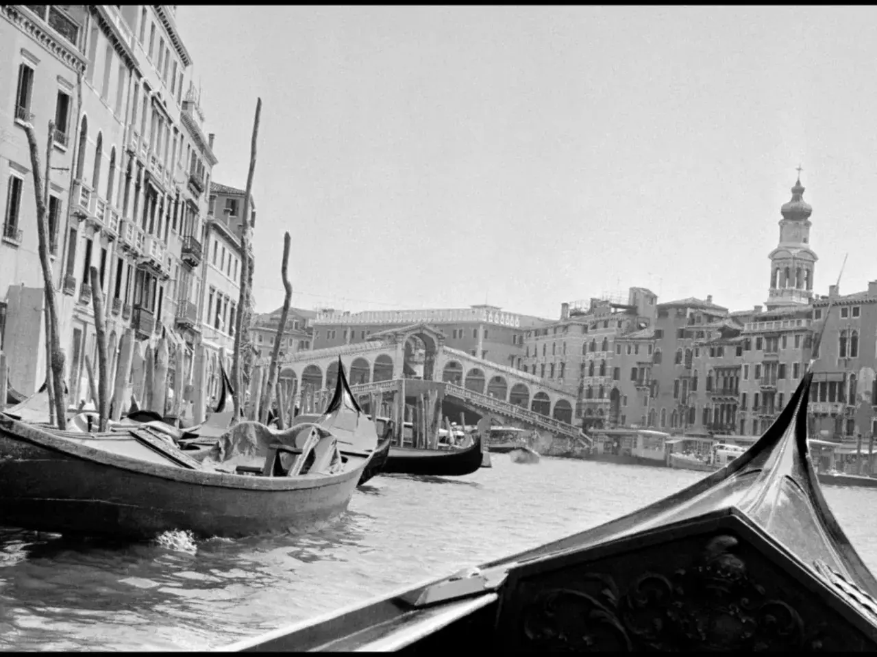 Gondole a Venezia, un classico scatto di Inge Morath. Il Ponte di Rialto sullo sfondo, con edifici storici e il Canal Grande.