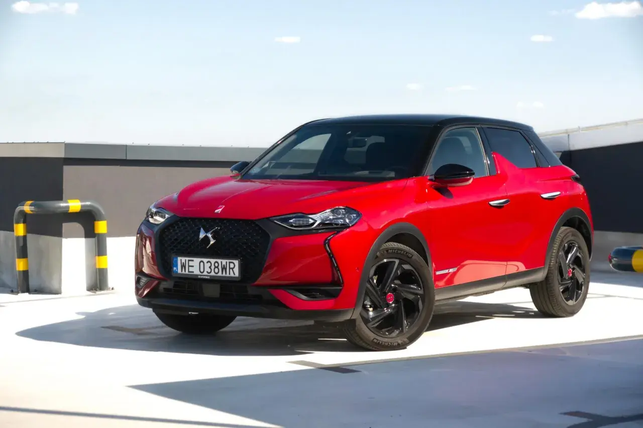 Czerwony DS3 Crossback z czarnym dachem na parkingu.