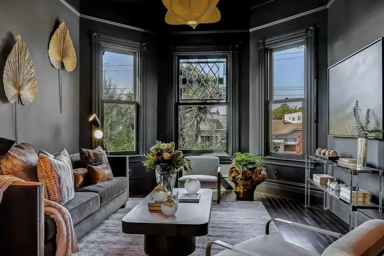 Elegancki salon w stylu wiktoriańskim. Ciemne ściany, ozdobne okna i stylowe meble tworzą przytulną atmosferę.