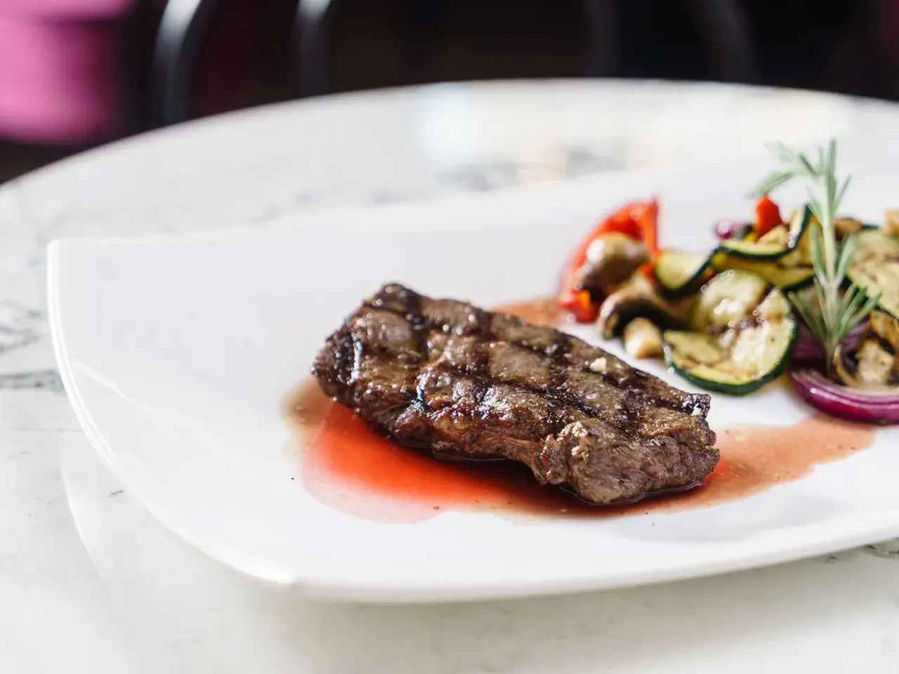 Saftiges Rinderfilet mit gegrilltem Gemüse und einer köstlichen Portweinsauce, garniert mit Rosmarin.