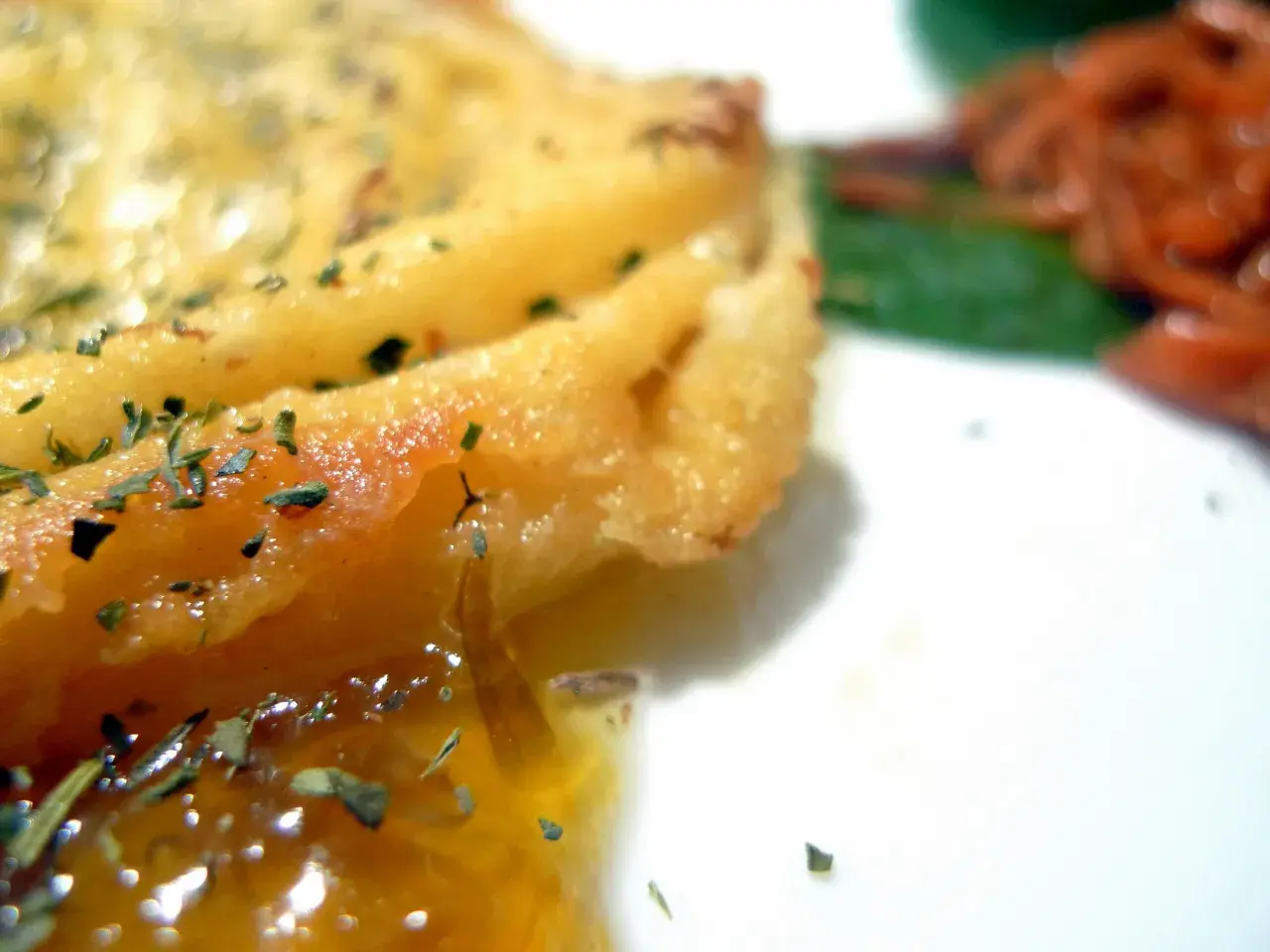 Queso provolone dorado y burbujeante, con hierbas, listo para servir. Descubre como hacer provolone a la plancha.