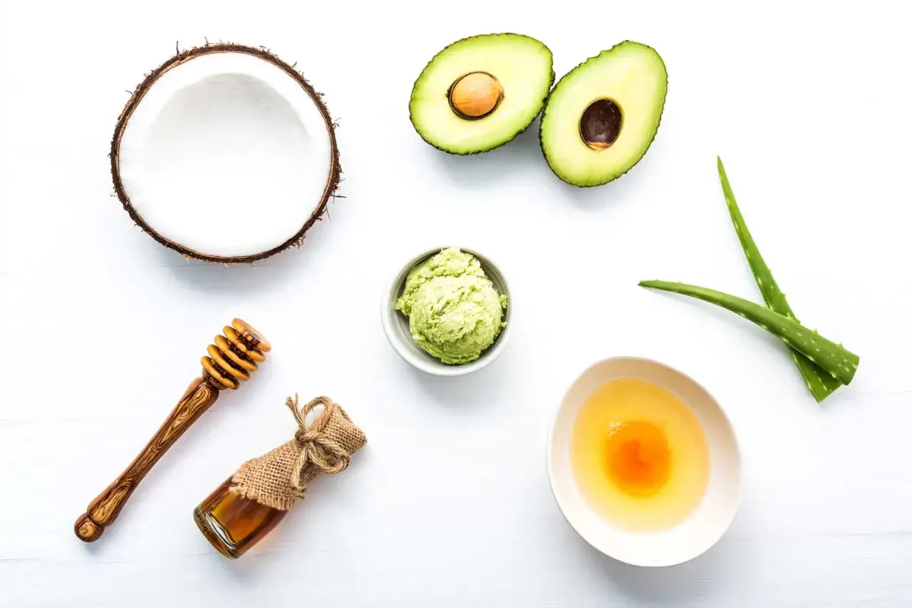 Ingredientes para una mascarilla casera para el pelo: aguacate, coco, aloe vera, miel y huevo.