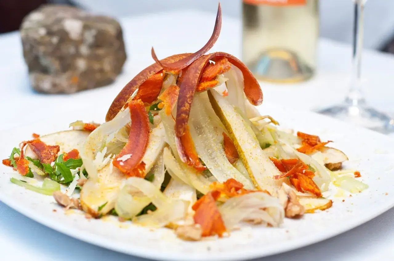 Salat mit Fenchel, Birne und feinen Streifen von **bottarga deutsch**. Ein Hauch von Luxus auf dem Teller.