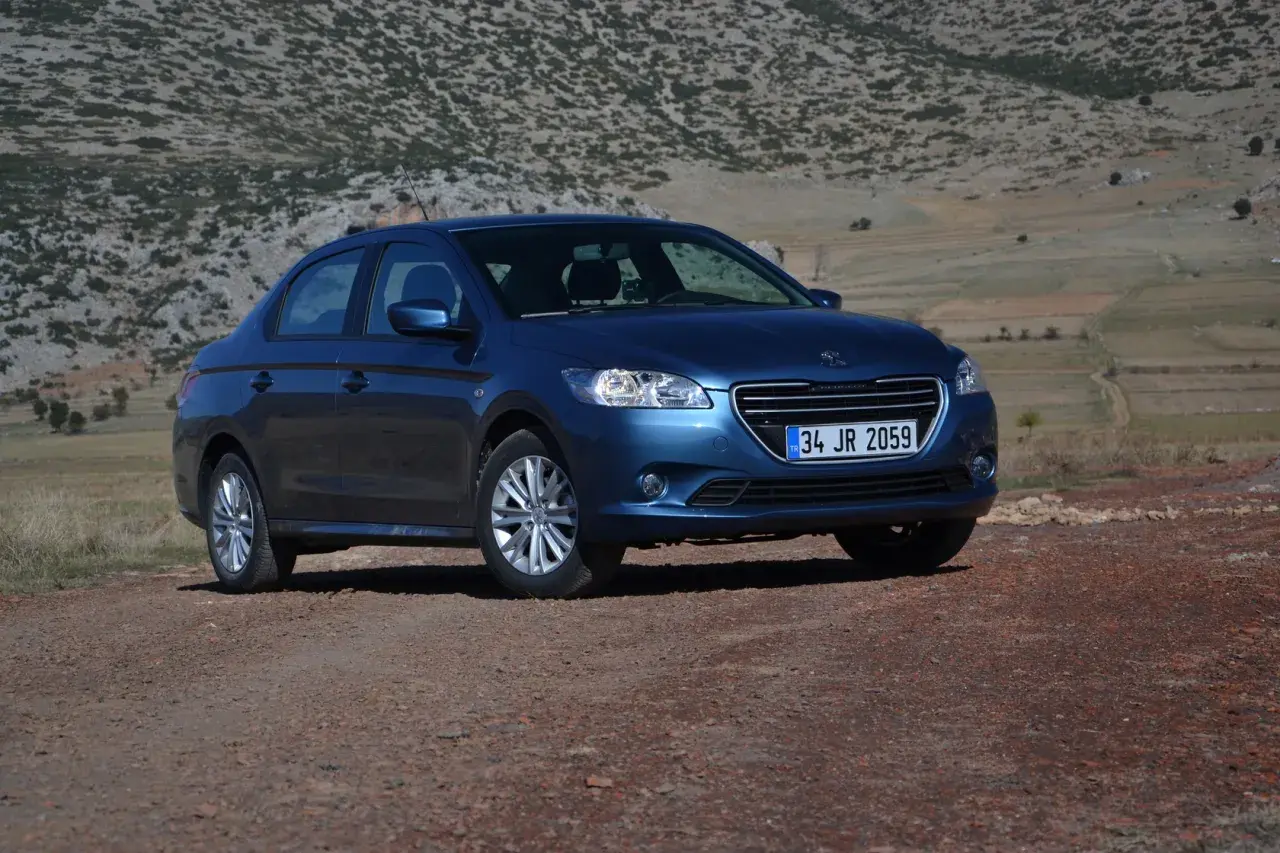 Niebieski Peugeot 301 na tle skalistego, pustynnego krajobrazu.